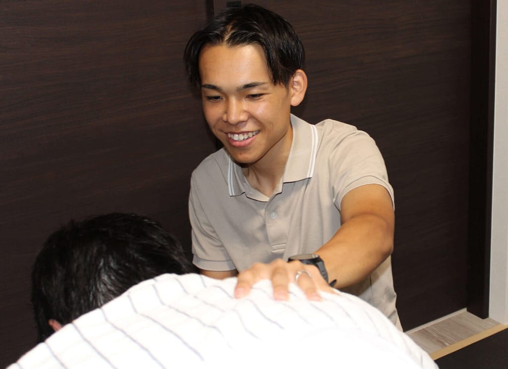 男性従業員とマッサージ中に会話する院長の写真