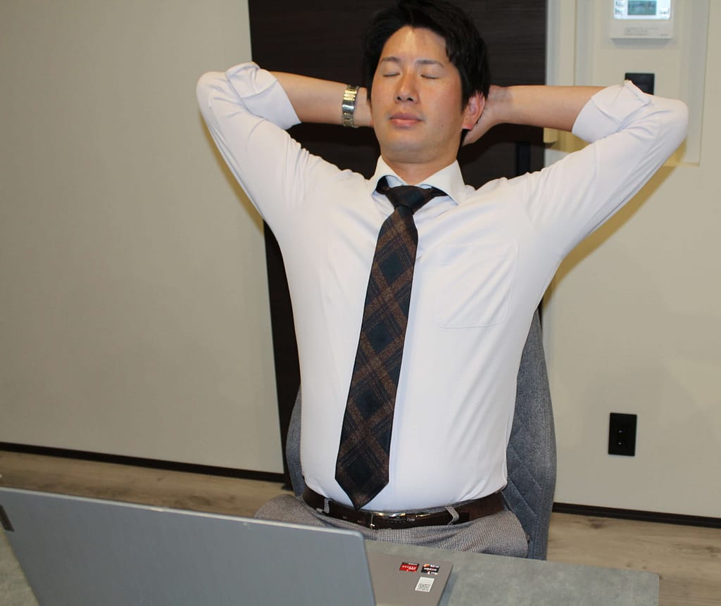 デスクワークをしている従業員が疲労を感じ悩んでいる写真